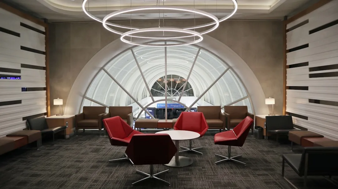 Upscale airport lounge with seating, windows overlooking planes, and complimentary refreshments
