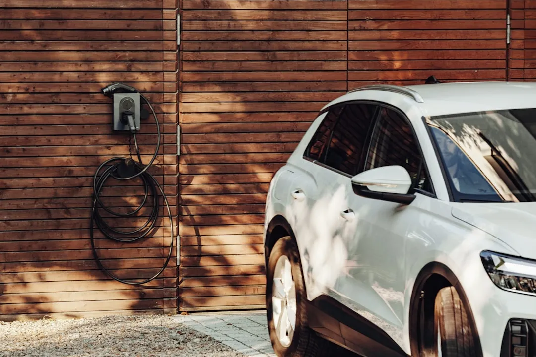 EV being charged at a public charging station with cable connected to vehicle.
