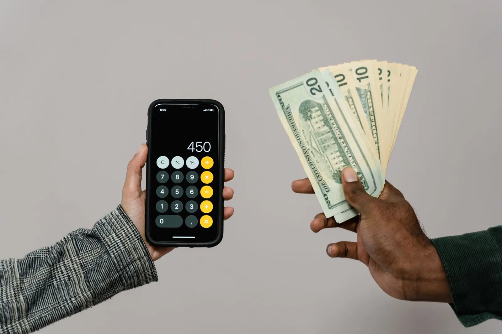 Person calculating costs with a calculator and financial documents on a desk