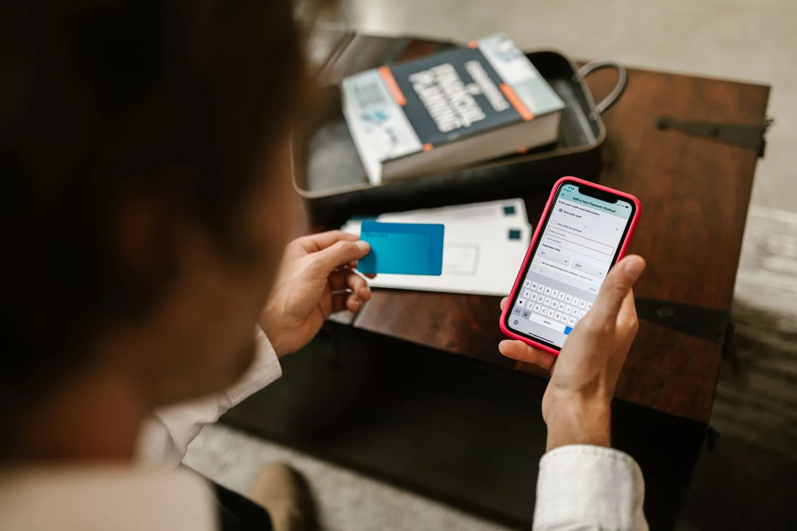 Smartphone displaying virtual card number in banking app next to a physical credit card