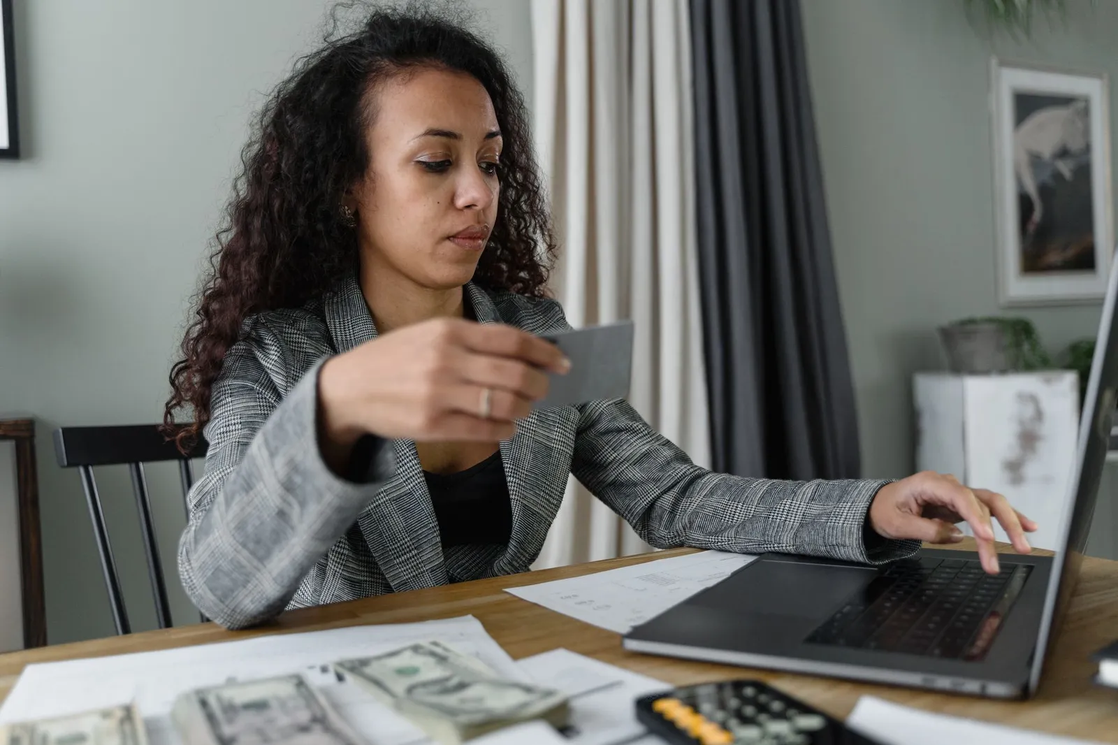 Person at desk calculating credit card balance and utilization ratio with calculator